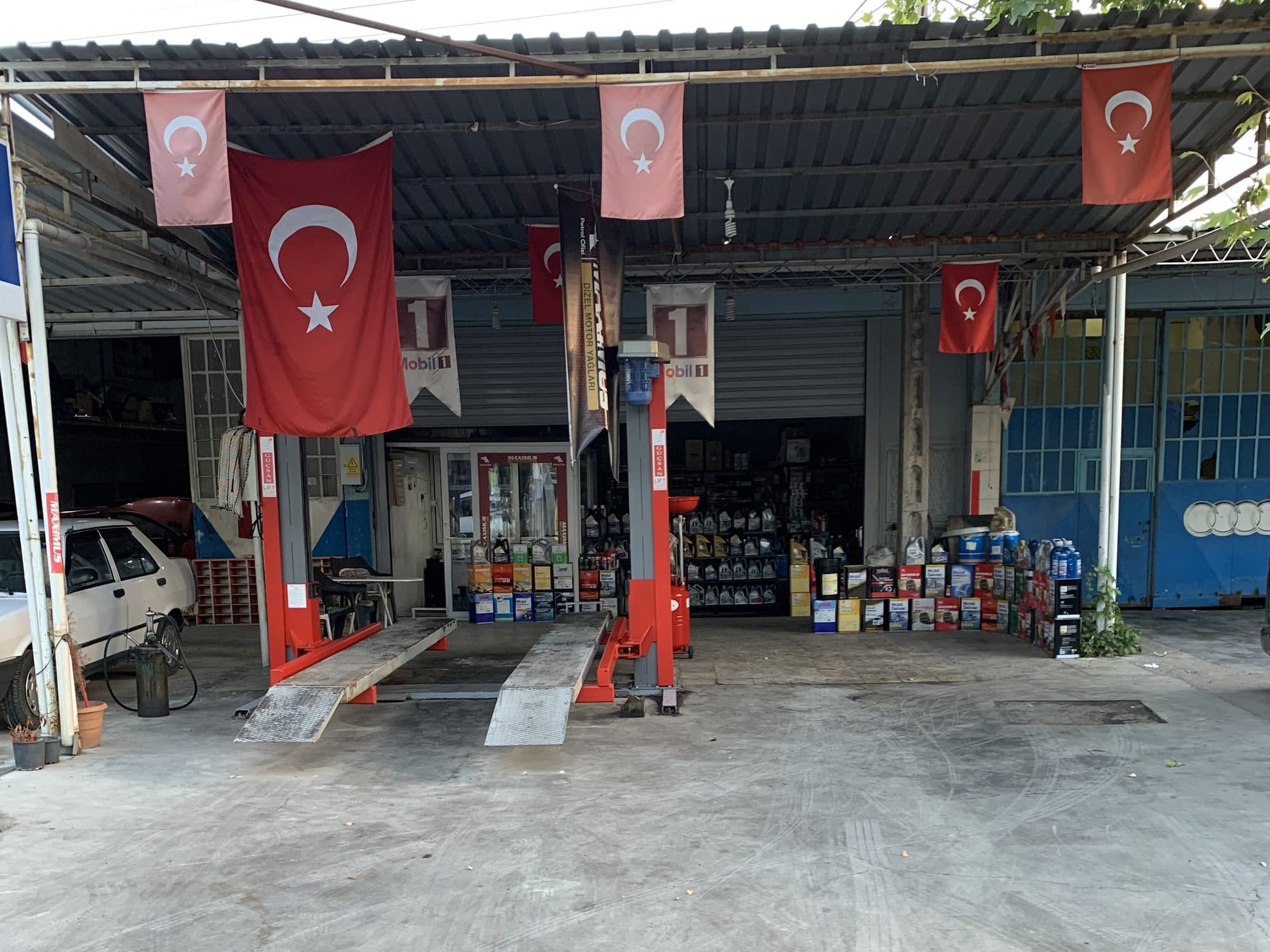 Dükkân önünde liftteki araçlar ve Türk bayrakları